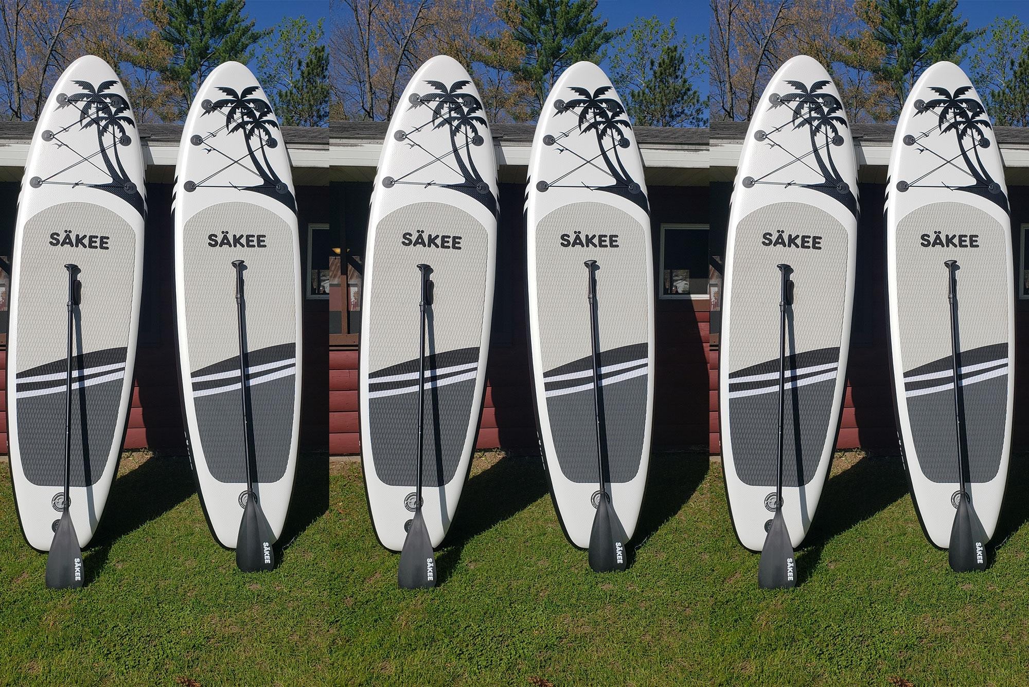 Row of six Sakee white and grey paddleboards